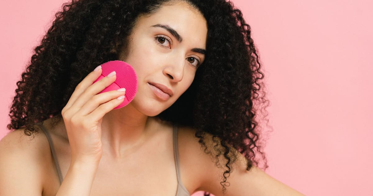 Limpiador facial eléctrico sobre fondo de baño