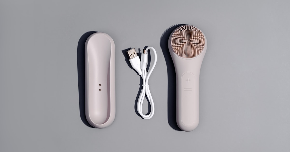 Mujer aplicando masajeador facial eléctrico en rutina de skincare